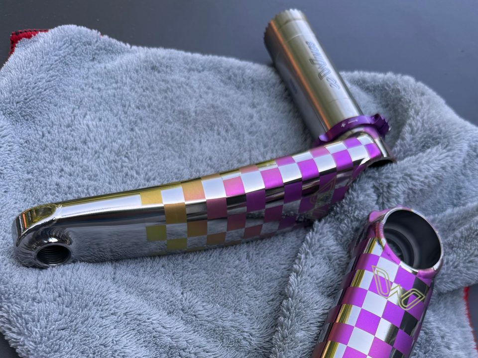 Cane Creek eeWings titanium crank arms anodized in a violet, pink and gold checkerboard
