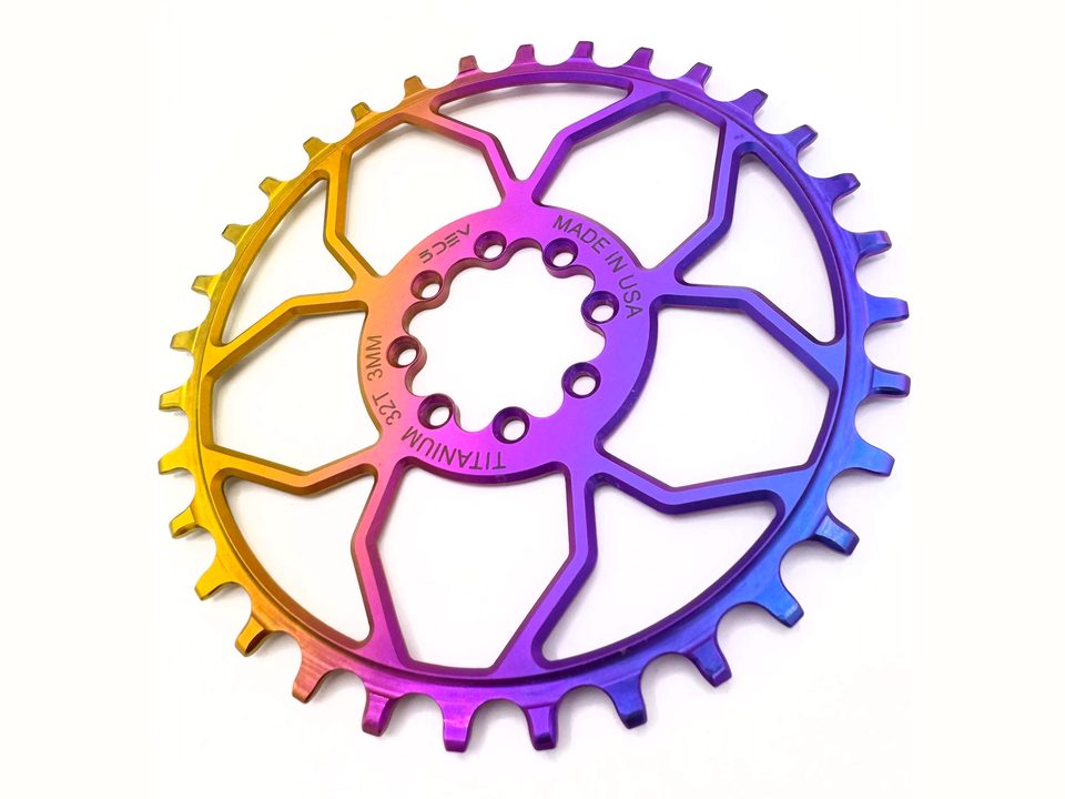 A 5Dev T-Type 8-bolt titanium chainring anodized in a gold-to-pink-to-blue fade