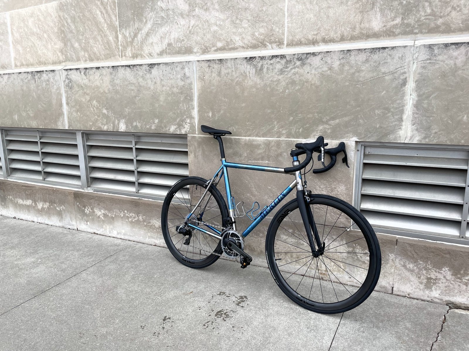 Merlin titanium road bike with blue contour anodizing, built with ENVE wheels