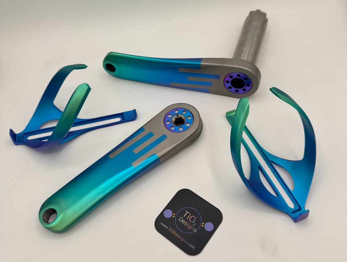 Anodized titanium crank arms and bottle cages in a teal-to-blue fade